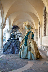 Venice Carnival masks and  costumes under the arcade of the Doges Palace St. Mark's Square