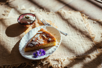 piece of orange and almond cake with cream on the table