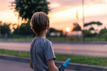 Junge bewundert den Sonnenuntergang auf der anderen Straßenseite