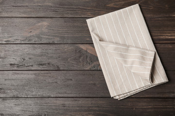 Fabric napkin and space for text on wooden background, top view