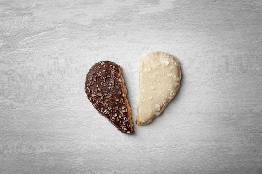 Halves of heart shaped cookies on gray background, top view. Relationship problems