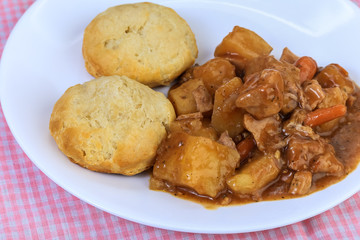 Pork Pot Roast with Biscuits on Pink Gingham Tabletop.