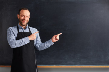 Cafe worker showing to blackboard.