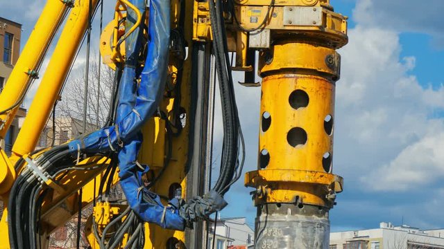 Heavy big excavator break trough holes for concrete colones for new road in construction site. Building a new streets in urban area, city town