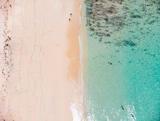 Vertical view of Pandawa Beach , Bali where 2 beachgoers are strolling in a line