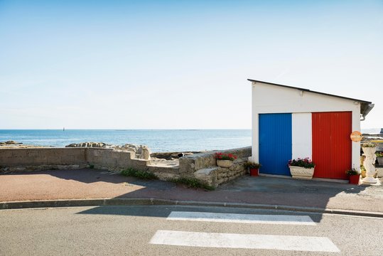 Garage by the sea painted in French national colours, Guilvinec, Finistere, Brittany, France, Europe