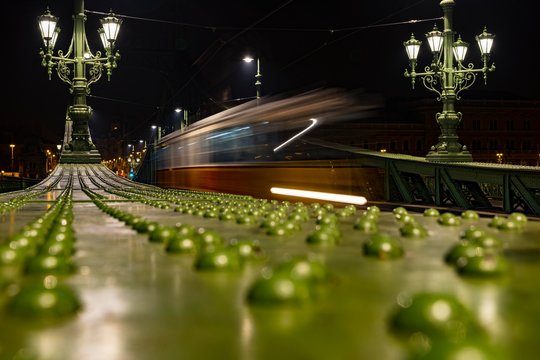 Parapet of the Liberty Bridge with driving tram at night, Budapest, Hungary, Europe