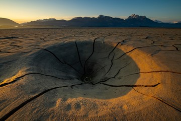 Cracky, dried out soil and Allgau Alps in the background at sunrise, Forggensee, Fussen, Ostallgau, Bavaria, Germany, Europe