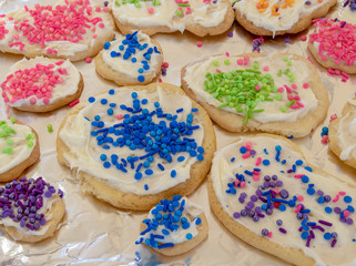 Sugar cookies covered with icing and sprinkles.