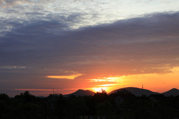 sunset or sunrise over country field and  mountain