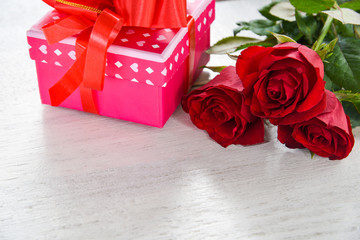 Valentines day gift box flower love concept pink gift box with ribbon bow red roses flower on white wooden