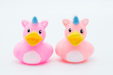Two pink unicorn rubber ducks on an isolated white background
