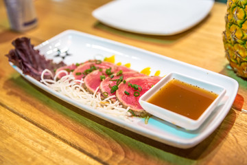 A Tuna sliced plate served with sauce