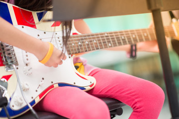 Asian girl study electric guitar in the music classroom
