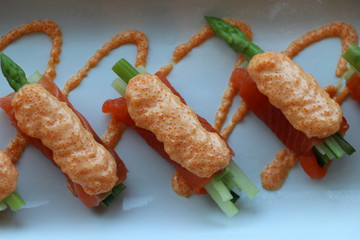 Salmon fillet wrap on asparagus vegetables and pour with the eggs of fish in the white plate.