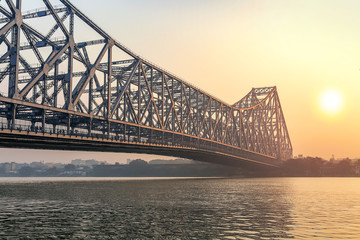Howrah bridge Kolkata on river Ganges at sunrise with winter haze. Howrah bridge is one of the busiest cantilever bridge in India