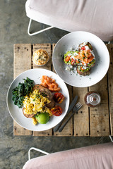 Healthy nutritious breakfast idea: avocado toast  with scrambled egg, salmon, spinach and grilled tomatoes. Plant-based concept for food.