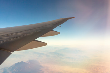 Obraz premium Clouds under the wing of an airplane. Amazing view from the window of the airplane during the flight