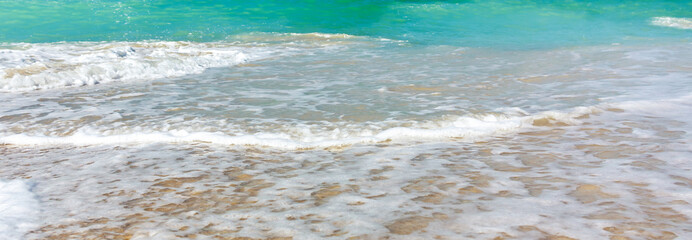 Wave surf on the sea coast, clean sea shore and turquoise water, horizontal panoramic image, background for banner