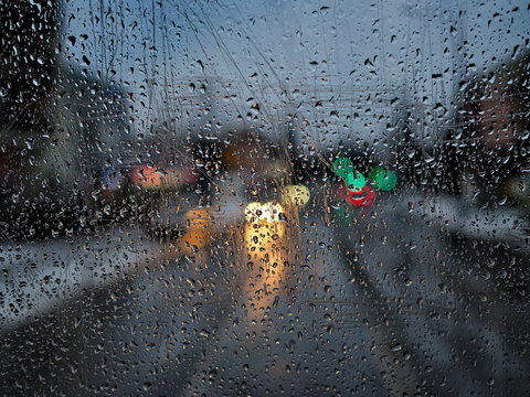 Rainy day road view with colorful lights from tram window