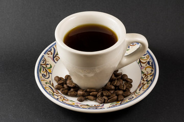 A cup of Antigua Coffee with some roasted coffe beans (pacamara)