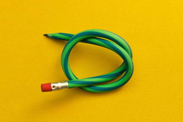 Flexible pencil . Isolated on yellow background