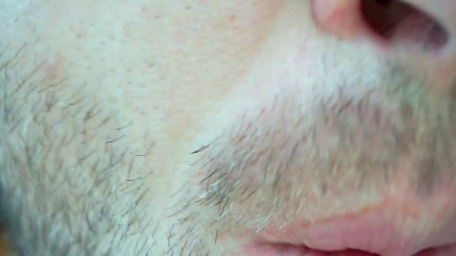 Extrime close-up man with stubble eats pizza and drinks juice from a plastic cup