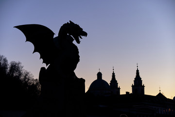 The fire Dragon symbol of the city of Ljubljana, seen on city bridge.  Night silhouette against...