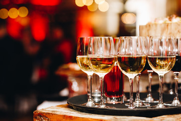 golden champagne in crystal glasses with party in the background 