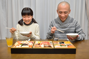 おせち料理を食べる親子