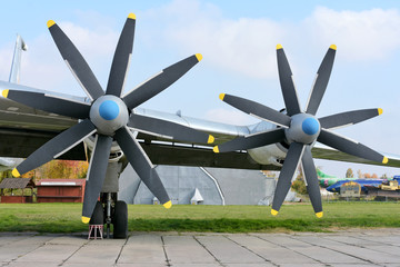 Retro plane with propellers on blue sky background. Airplane details with clouds. Aviation...