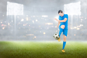 Naklejka premium Handsome asian soccer player man in action with ball