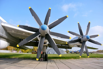 Retro plane with propellers on blue sky background. Airplane details with clouds. Aviation...