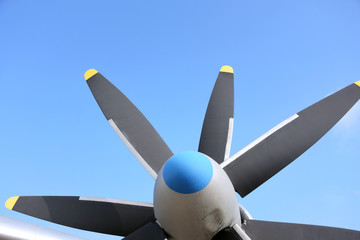 propeller blade of an airplane on blue sky background. Metal black blade of vintage plane. Part of retro airliner. Aviator transport industry. Rotor turbine of an old airplane. Jet engine