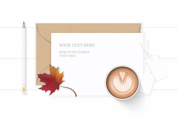 Fototapeta na wymiar Flat lay top view elegant white composition letter kraft paper envelope autumn maple leaf tags and pencil coffee on wooden background