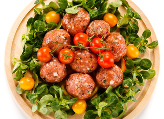 Raw meatballs on cutting board on white background