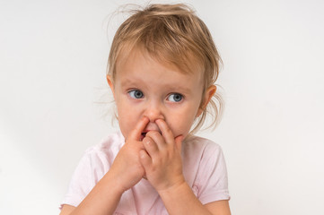 Baby girl is picking her nose with finger inside