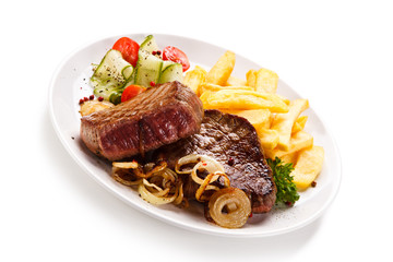 Grilled beefsteak with french fries and vegetable salad on white background