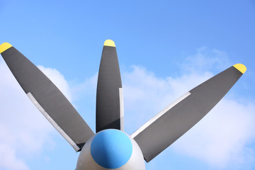 propeller blade of an airplane on blue sky background. Metal black blade of vintage plane. Part of retro airliner. Aviator transport industry. Rotor turbine of an old airplane. Jet engine