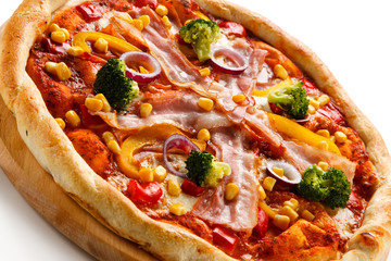 Pizza with bacon and vegetables on cutting board on white background