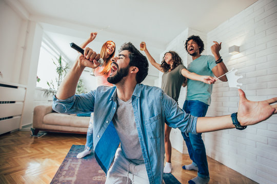 Group Of Friends Playing Karaoke At Home. Concept About Friendship, Home Entertainment And People