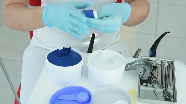 The dentist makes a cast of teeth for prosthetics from a special plastic mass of white and blue. orthopedic dentistry