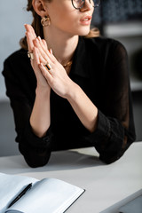 woman in black clothes and glasses sitting on chair