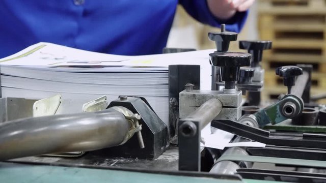 printing press newspaper or brochure worker standing near conveyor print house