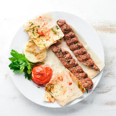 Lamb Kebab. Lavash and spices. On a white wooden background. Top view.