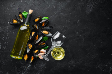 A bottle of white wine and mussels. Top view. Free space for your text. On the old background.