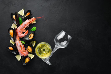 A bottle of wine and seafood. Top view. Free space for your text. On the old background.