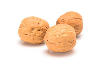 Three whole walnuts, close up macro, isolated on a white background.