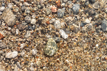 Clear water and colorful pebbles on the sea