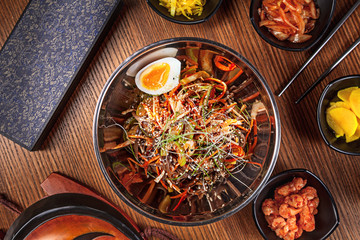 Asian food. korean cuisine. Top view spicy korean noodles with kimchi ыуе and egg with vegetables. Traditional korean cuisine set. Picture for recipe. Copy space for text logo or brand.